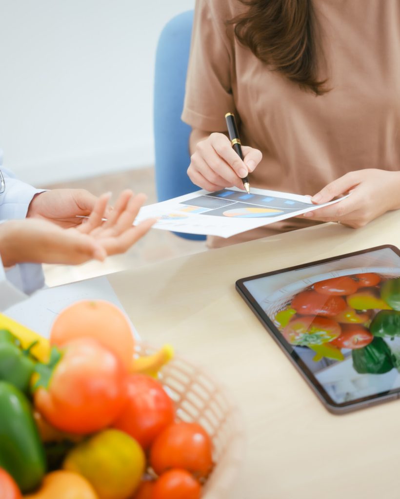 A young female nutritionist expert talks to a female patient at  table,recommending a healthy diet